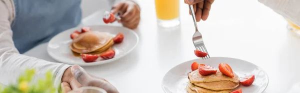 Cropped view of african american father and child holding hands during breakfast, banner — Stock Photo