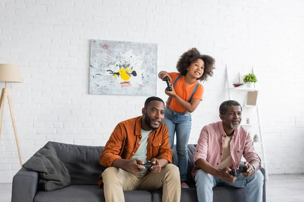 KYIV, UKRAINE - JULY 17, 2021: positive african american family with daughter playing video game at home — Stock Photo