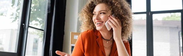 Щаслива бізнес-леді розмовляє на смартфоні під час роботи в офісі, банер — стокове фото