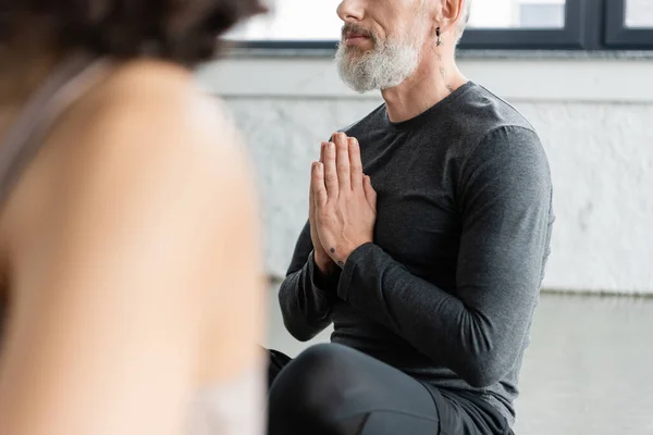 Vista ritagliata dell'uomo di mezza età che pratica anjali mudra in classe di yoga — Foto stock