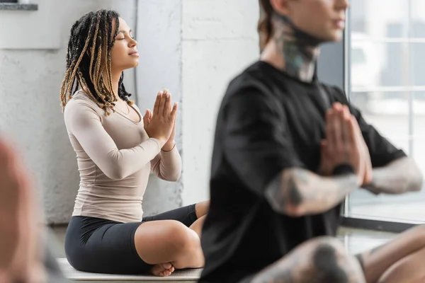 Junge afrikanisch-amerikanische Frau macht anjali mudra in Yoga-Gruppe — Stockfoto