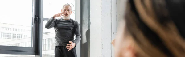 Mature coach explaining asana to blurred african american woman in yoga class, banner — Stock Photo