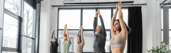Interracial pessoas praticando Crescent Lunge pose no estúdio de ioga, banner — Fotografia de Stock