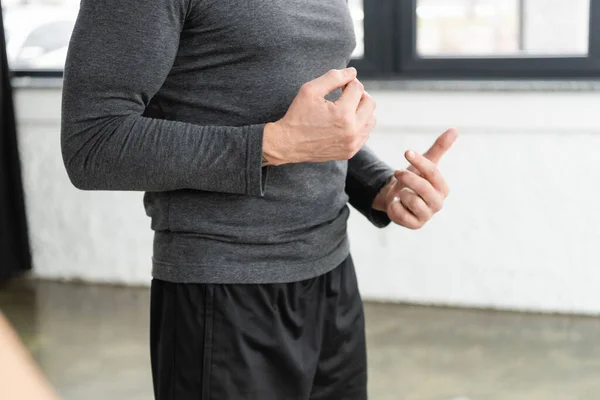 Vista recortada del entrenador en ropa deportiva haciendo gestos en clase de yoga - foto de stock