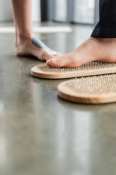 Vue recadrée de l'homme pratiquant ongle debout sur la planche sadhu dans le studio de yoga — Photo de stock