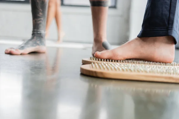 Cropped view of man standing on sadhu board in yoga class — Stock Photo
