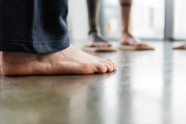 Обрезанный вид человека с босыми ногами, стоящего в студии йоги — стоковое фото