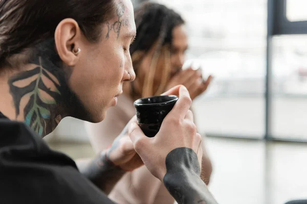 Homme tatoué avec les yeux fermés sentant thé puer infusé dans une tasse traditionnelle — Photo de stock