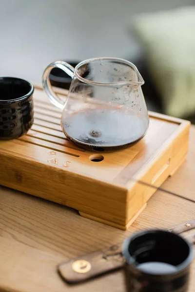 Jarro de vidro com chá puer fabricado perto da tradicional xícara japonesa — Fotografia de Stock