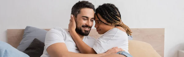 Молодая африканская американка с дредами обнимающая радостного бородатого бойфренда в спальне дома, баннер — стоковое фото