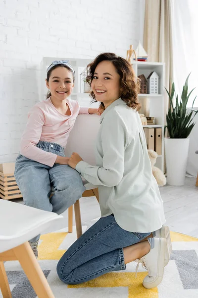Smiling speech therapist and pupil looking at camera in consulting room — Stock Photo