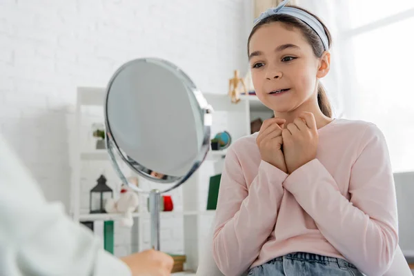 Sorrindo criança pré-adolescente olhando para o espelho perto da fonoaudióloga no consultório — Fotografia de Stock
