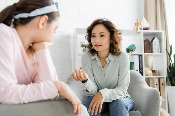 Psicólogo falando com criança pré-adolescente turva em consultório — Fotografia de Stock