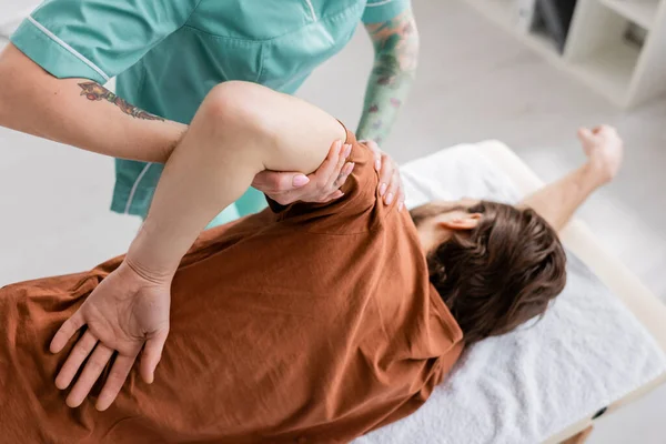 Osteopath doing rehabilitation massage on injured arm of man in rehab center — Stock Photo