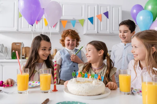 Group of happy children celebrating birthday next to tasty cake during party at home — Stock Photo