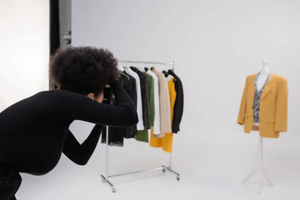 African american photographer taking picture of new trendy clothing collection in photo studio — Stock Photo