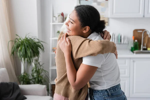 Heureux multiracial travailleur social étreignant femme âgée avec les cheveux gris — Photo de stock