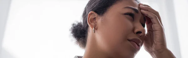 Unzufriedene multirassische Frau mit Depressionen berührt Stirn zu Hause, Banner — Stockfoto