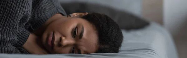 Frustrierte Frau mit Depressionen liegt zu Hause auf verschwommenem Bett, Transparent — Stockfoto