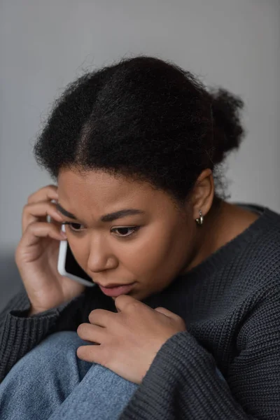 Mujer joven multirracial con depresión llamando a la línea de ayuda en casa - foto de stock