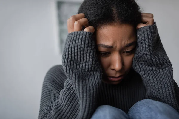 Напряженная многорасовая женщина с депрессией трогательной головой дома — стоковое фото