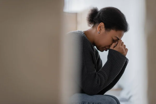 Side view of multiracial woman with mental problem crying at home — Stock Photo