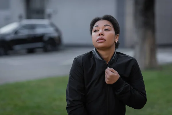 Multiracial woman with psychological problem wearing jacket on urban street — Stock Photo