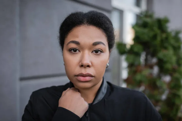 Portrait de femme multiraciale avec dépression regardant la caméra dans la rue urbaine — Photo de stock