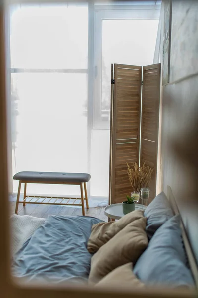 Banc de chevet et écran pliant dans la chambre près du lit et de la table de chevet — Photo de stock