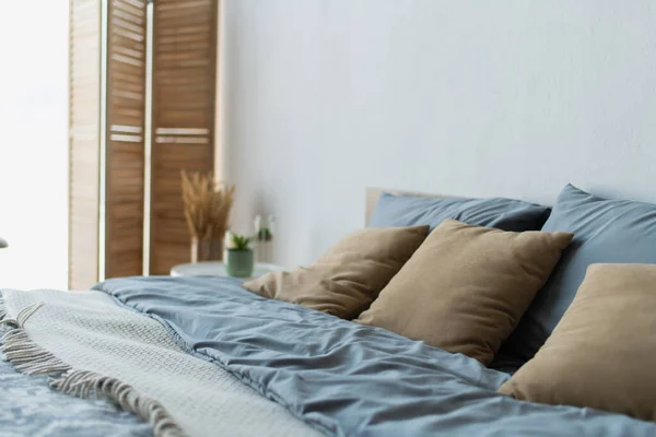 Oreillers sur lit confortable dans une chambre floue — Photo de stock