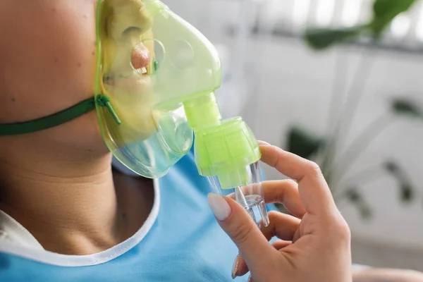 Cropped view of diseased woman breathing in oxygen mask in hospital ward — Stock Photo