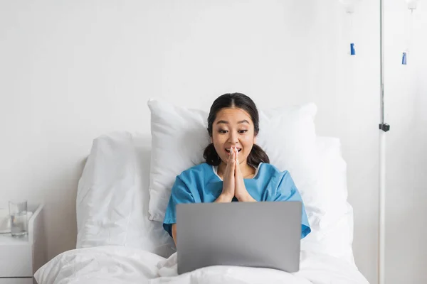 Animado ásia mulher gesturing durante vídeo chamada no laptop no hospital ward — Fotografia de Stock