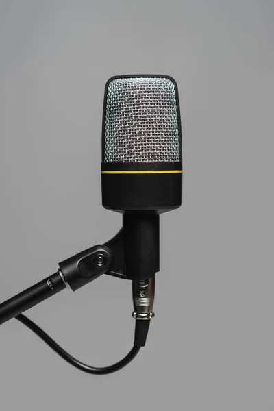 Vista de perto do microfone com fio preto em suporte de metal isolado em cinza, foto de estúdio — Fotografia de Stock