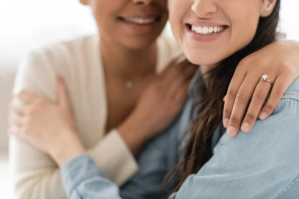 Cropped view of multiracial lesbian woman with engagement ring hugging girlfriend — Stock Photo