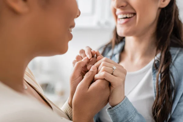 Cropped view of engaged lesbian couple smiling and holding hands — Stock Photo