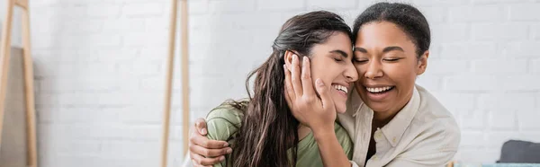 Freudige multirassische Frau umarmt glückliche Freundin in neuem Haus, Banner — Stockfoto