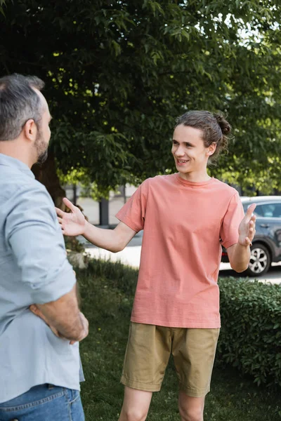 Happy teenage boy welcoming bearded father in green park — Stock Photo