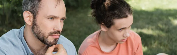 Cher et barbu père assis à côté de fils adolescent dans le parc vert, bannière — Photo de stock