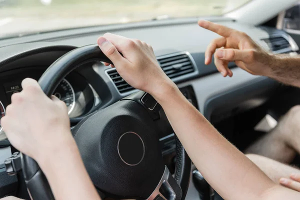 Corte vista de pai apontando para longe com o dedo enquanto adolescente filho carro de condução — Fotografia de Stock