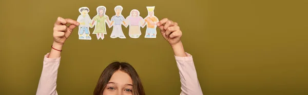 Cropped view of preteen kid holding drawn paper characters above head during child protection day celebration on khaki background, banner — Stock Photo