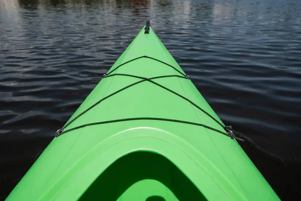 Vista ad alto angolo della parte anteriore del kayak sportivo verde brillante sulla superficie dell'acqua calma in estate, ricreazione dell'acqua, destinazione di vacanza, fuga estiva, concetto — Foto stock