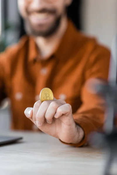 QUIIV, UCRÂNIA - OUTUBRO 18, 2022: foco seletivo de bitcoin dourado na mão de empresário de sucesso na camisa sorrindo no fundo borrado, visão recortada — Fotografia de Stock