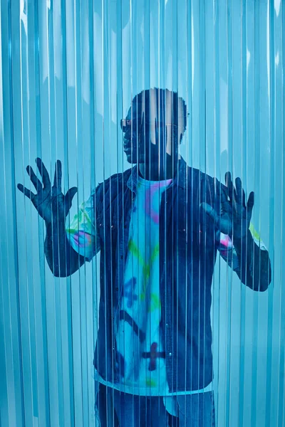 Homem afroamericano elegante em óculos de sol, colete jeans e camiseta colorida tocando folha de policarbonato azul, tiro de moda e roupa de rua, roupas DIY, estilo de vida sustentável — Fotografia de Stock