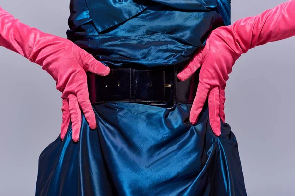 Обрезанный вид на модную молодую женщину в коктейльном платье и розовые перчатки трогательные бедра, позируя изолированы на сером, современное поколение z моды концепции, детали, крупным планом — стоковое фото