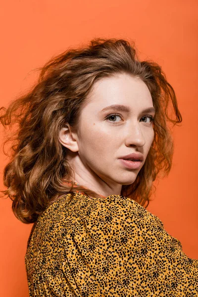 Portrait of stylish redhead woman with no-makeup look posing in yellow blouse and looking at camera isolated on orange, stylish casual outfit and summer vibes concept, Youth Culture — Stock Photo