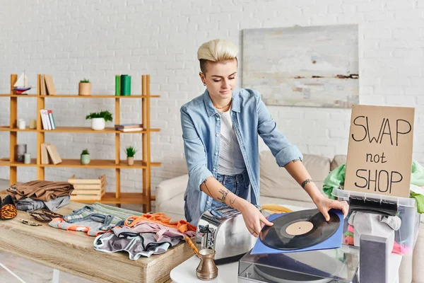 Gemeinsamer Konsum, lächelnde tätowierte Frau mit Schallplatte in der Nähe von Plattenspieler, Toaster, Cezve, Kleidung und Swap-Karte, nachhaltiges Leben und Kreislaufwirtschaftskonzept — Stockfoto