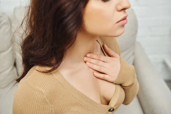 High angle view of young brunette woman in casual jumper massaging neck during lymphatic system self-massage at home, self-care ritual and holistic wellness practices concept, tension relief — Stock Photo
