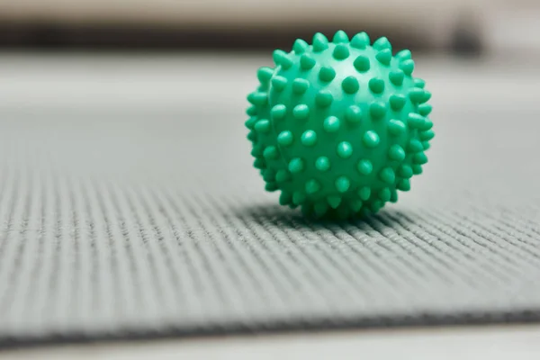 Close up view of handle massage ball on fitness mat on floor at home, natural health practices and home-based massage concept, health and relaxation, beauty and wellness routine — Stock Photo