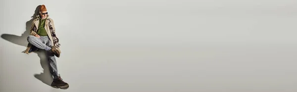Ausdrucksstarke Persönlichkeit, hochauflösende Ansicht eines älteren Hipstermannes in stilvoller Freizeitkleidung und dunkler Sonnenbrille auf grauem Hintergrund mit Schatten, modisches Alternskonzept, Banner mit Kopierraum — Stockfoto