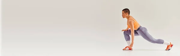 Movimento de positividade do corpo, visão lateral da mulher curvilínea e de cabelos curtos fazendo lunges em fundo cinza, aptidão feminina, empoderamento, motivação, treino, sportswear, força e saúde, banner — Fotografia de Stock